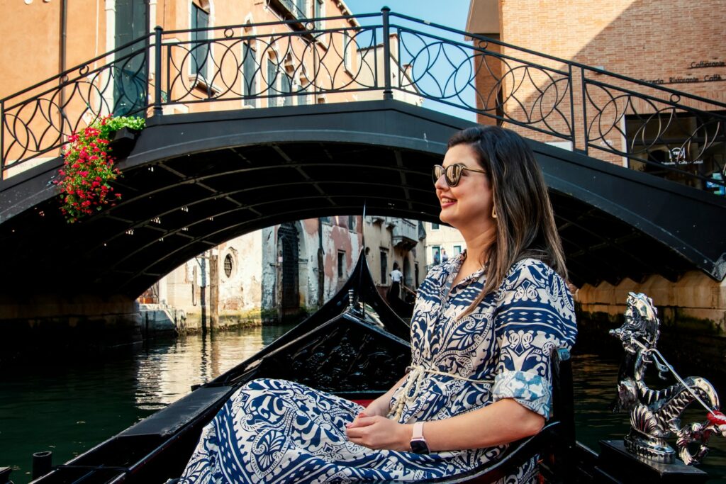 a woman sitting on a boat in a canal