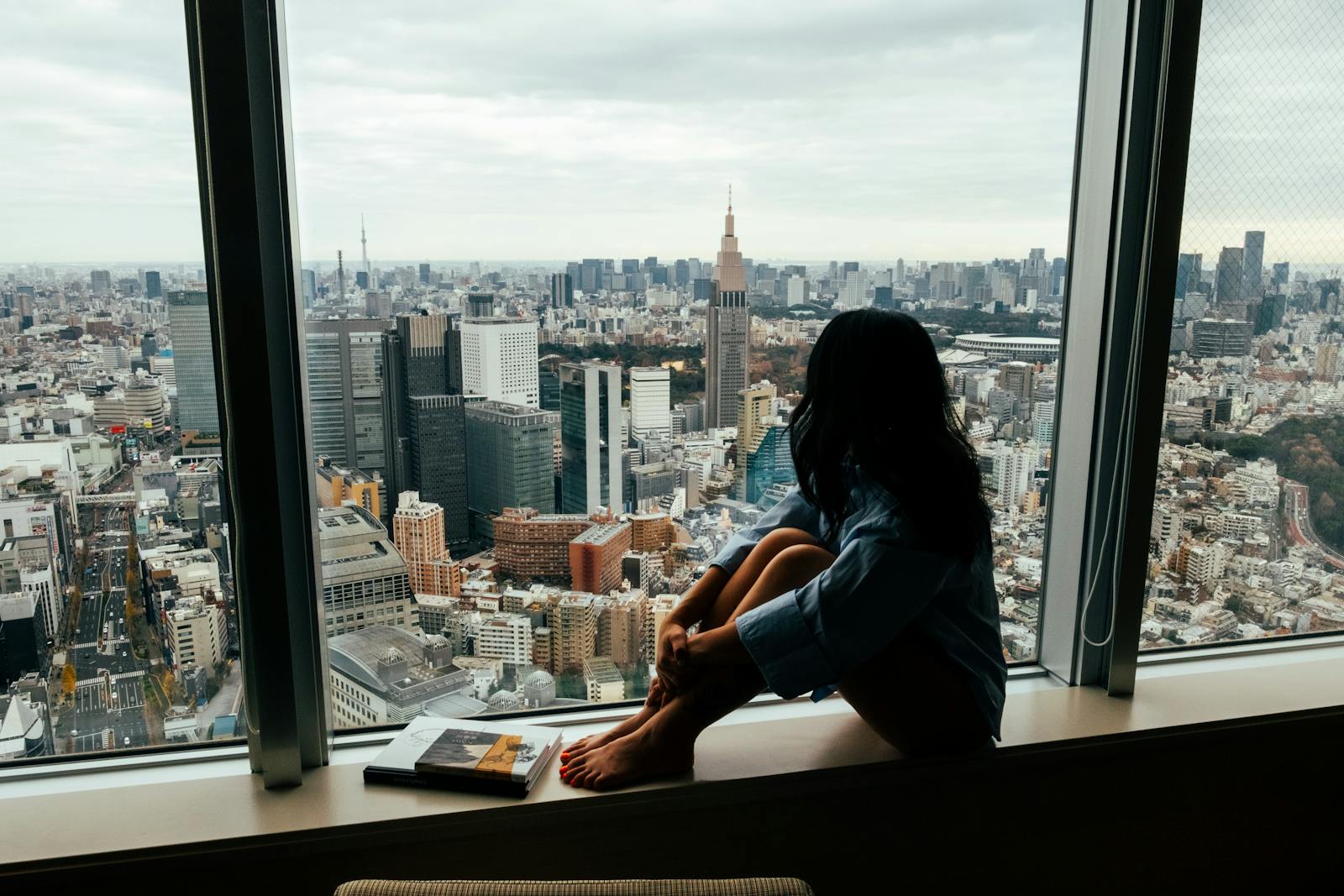 Woman enjoying a peaceful view over Tokyo, Japan from a high-rise building.